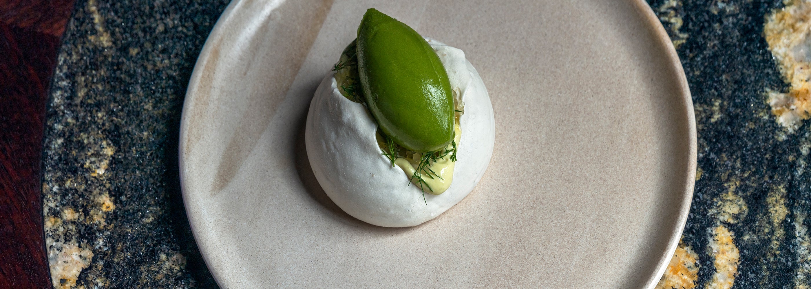 A dessert on a white plate on a marble table